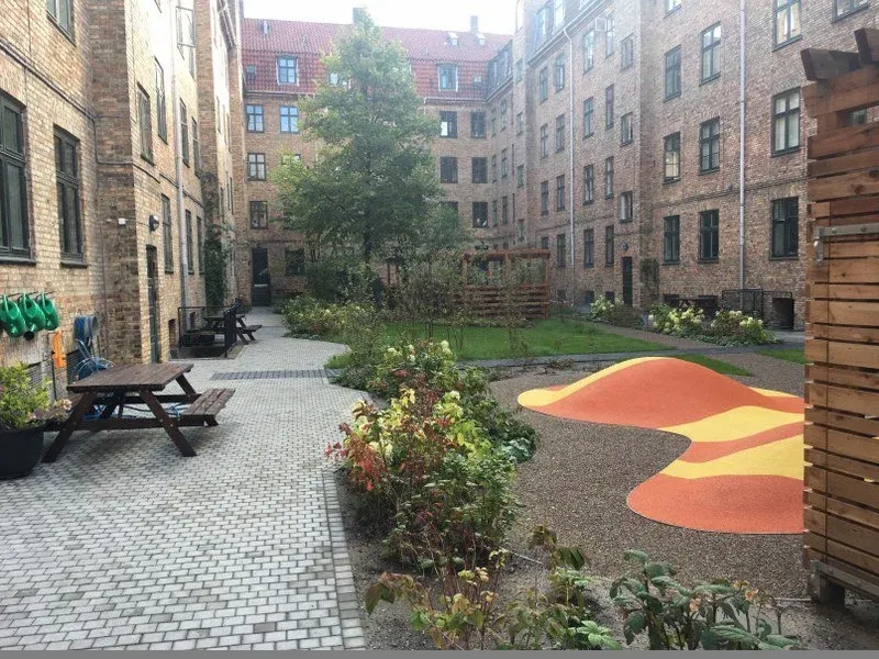 Permeabel belægning og lavtliggende plæne der kan oversvømmes ved skybrud