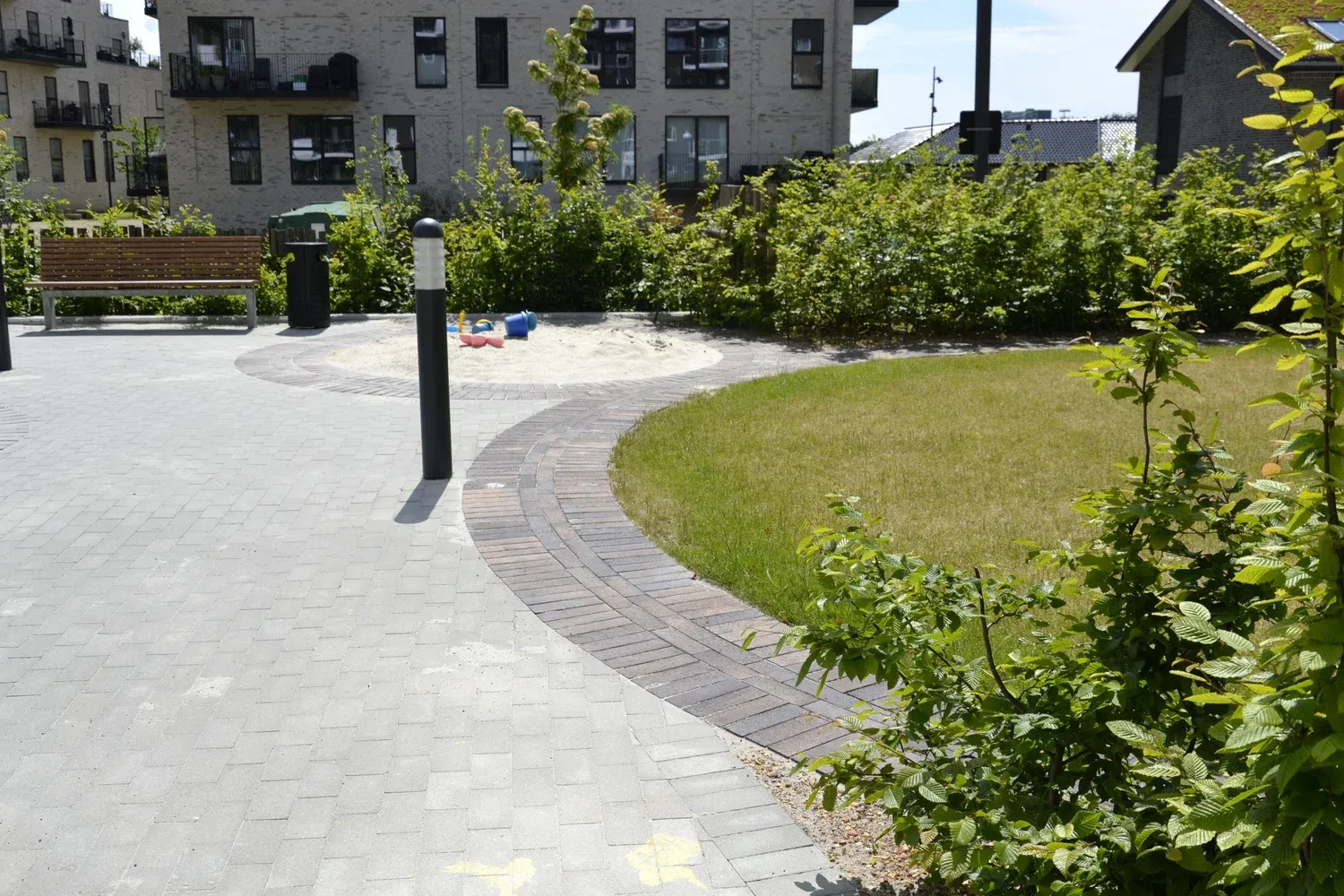 Lavtliggende plæne med stauder der både kan oversvømmes og bruges til ophold