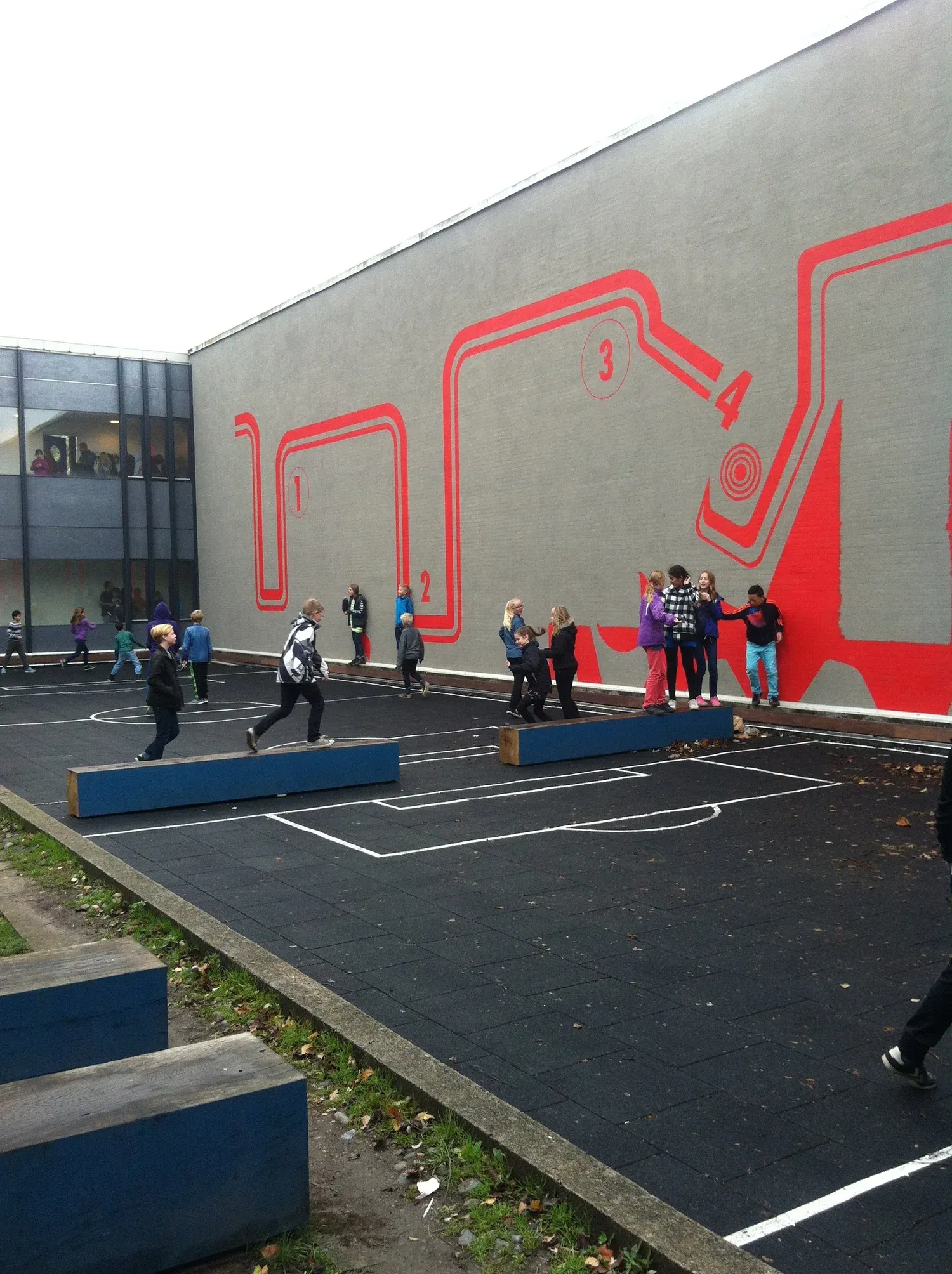 Akustikvæg i en Gladsaxe-skoles fællesrum med elevtegnet mønsterspil i træfiltret