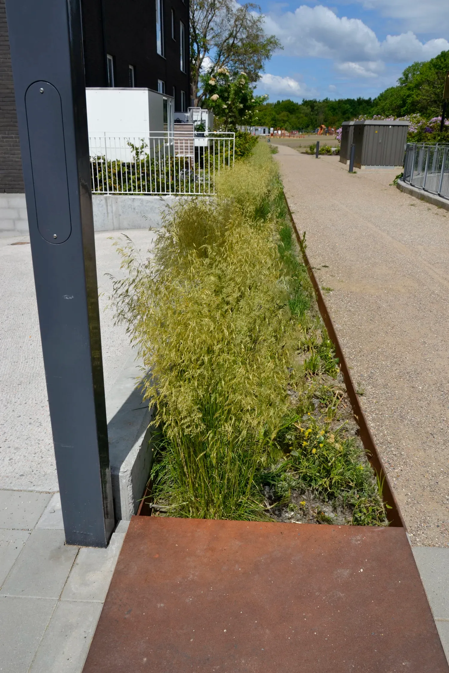 Fælles gårdrum i Irmabyen med legeområde, regnbede og opholdspladser mellem boligblokkene