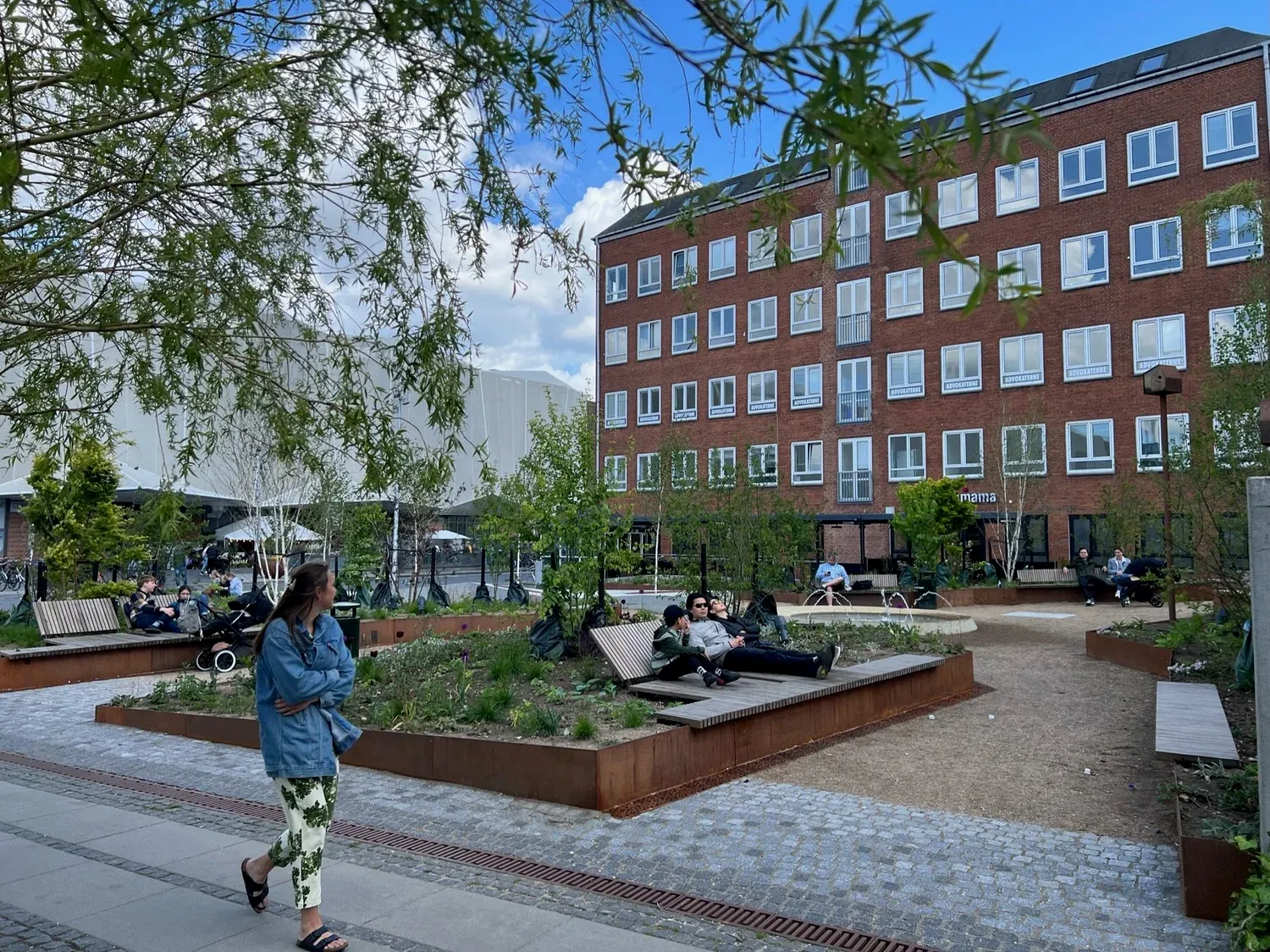 Bodil Kochs Have set fra hovedindgangen med blomstrende stauder og bænke i egetræ