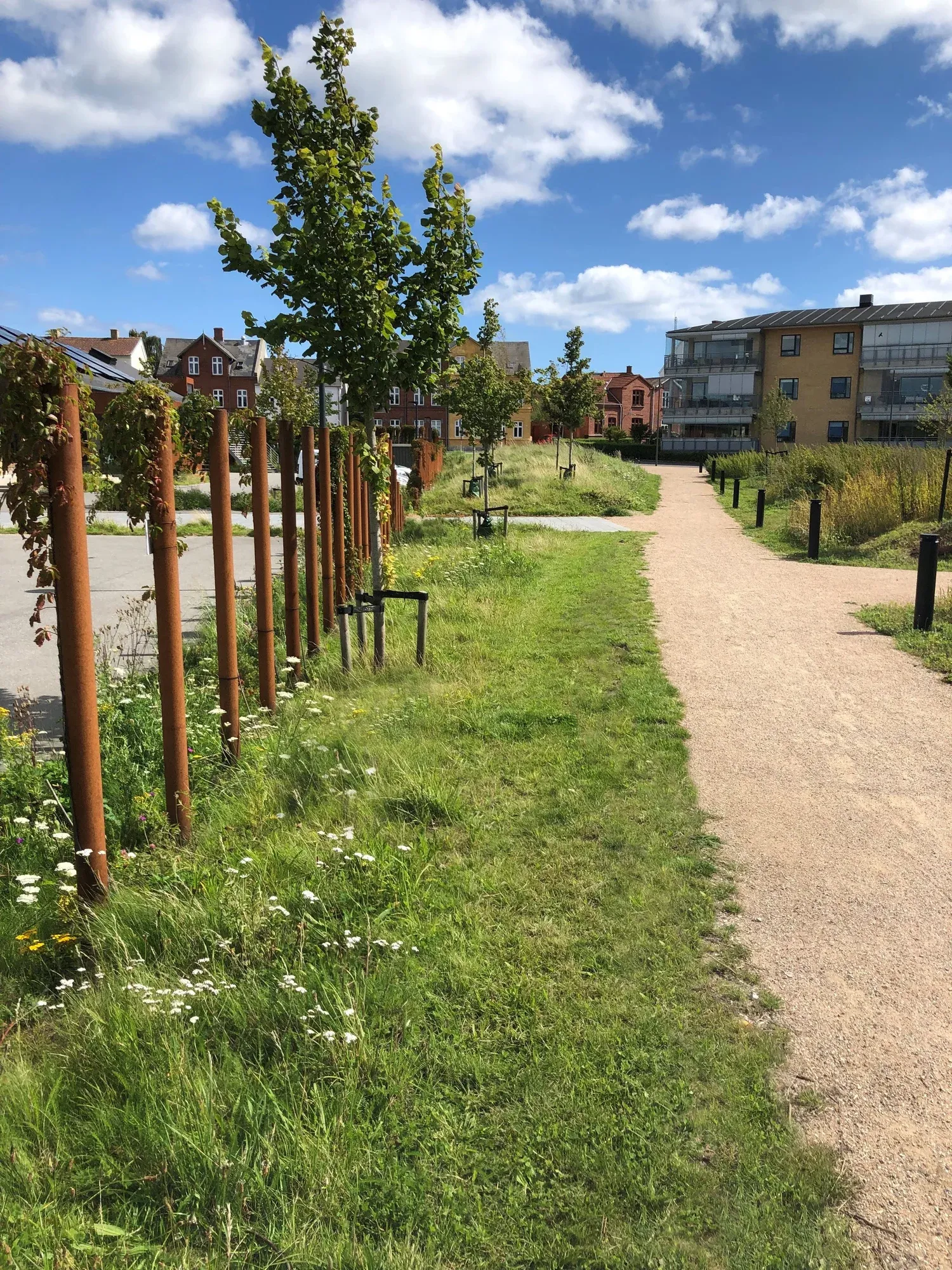 Nyborg By- og Havnepark set fra kajen mod bymidten med nyplantede træer og bevarede industrispor